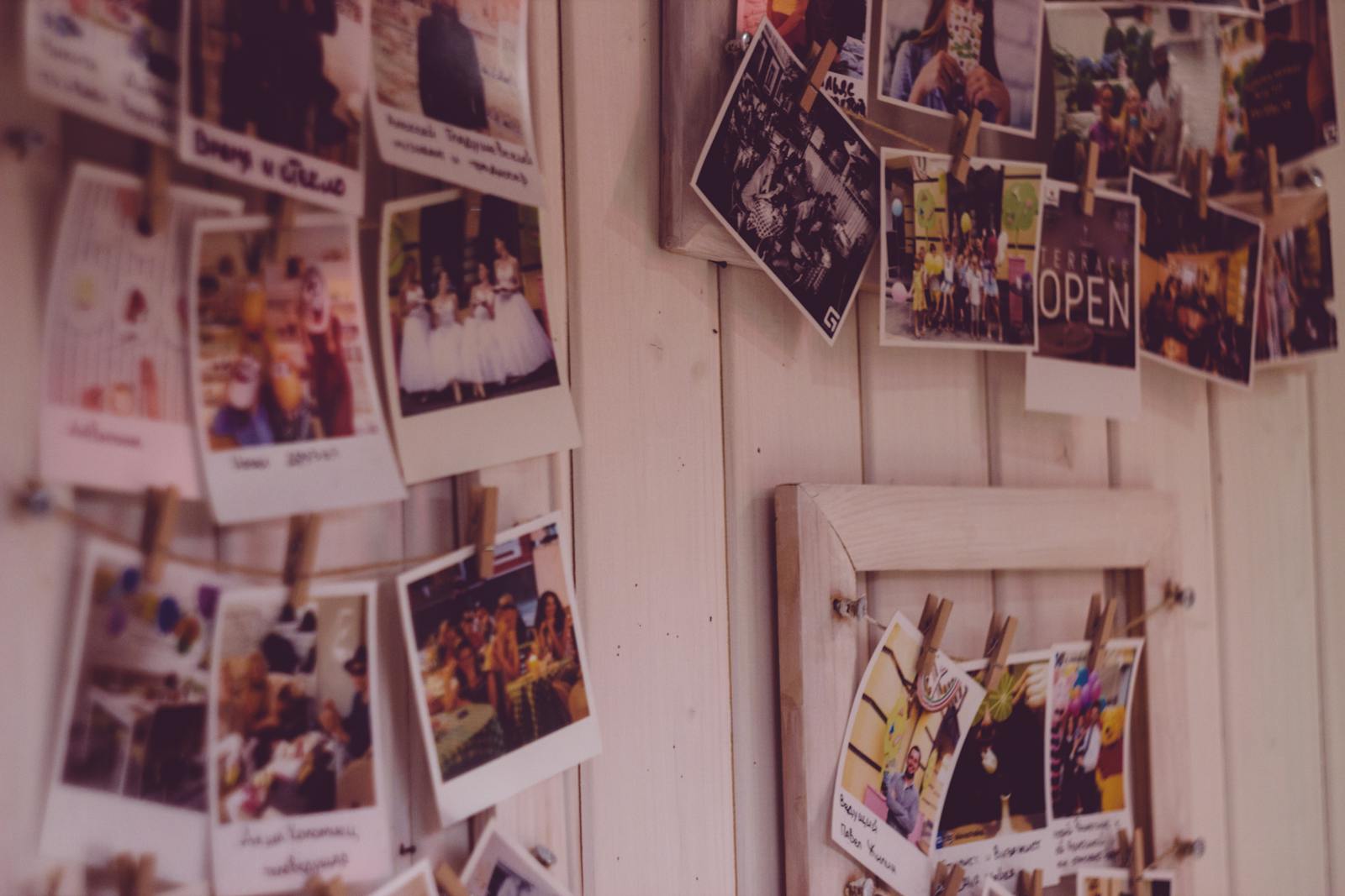 Foto pessoal com mural de fotos polaroid em parede branca minimalista